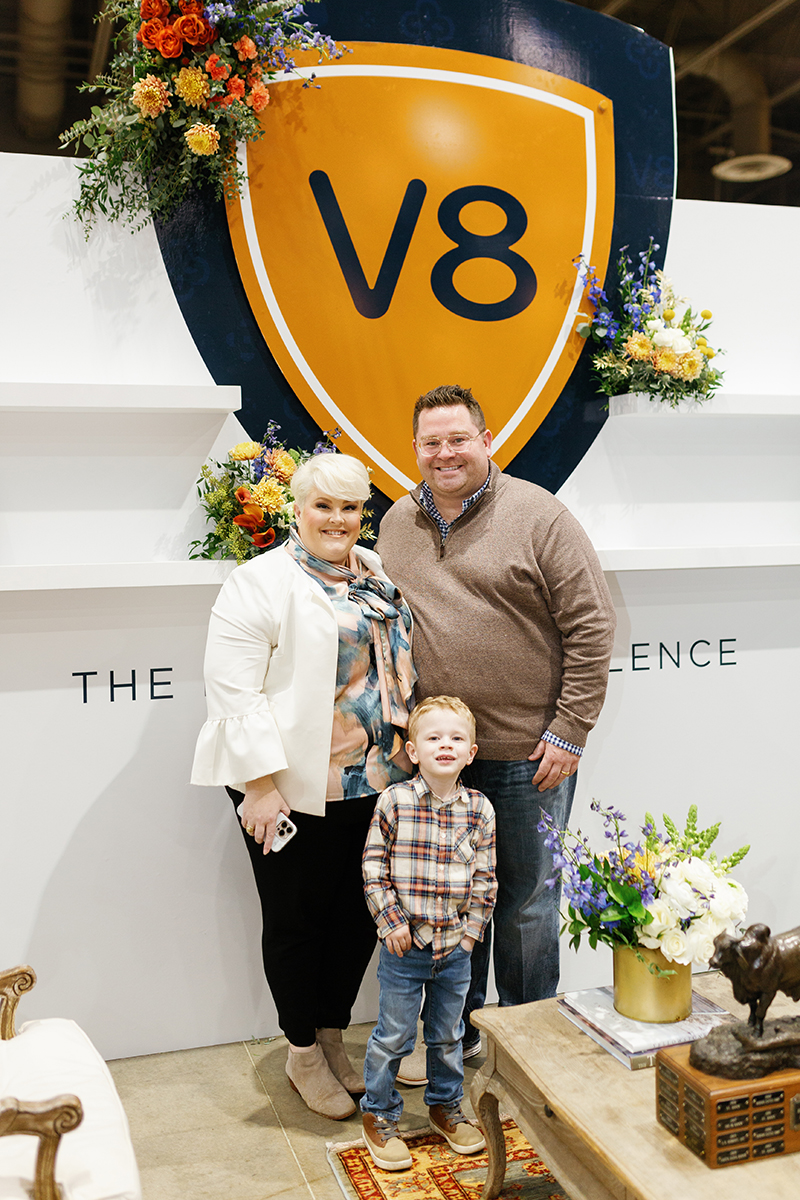 Catherine, Luke, and Knox Neumayr standing at the V8 shield