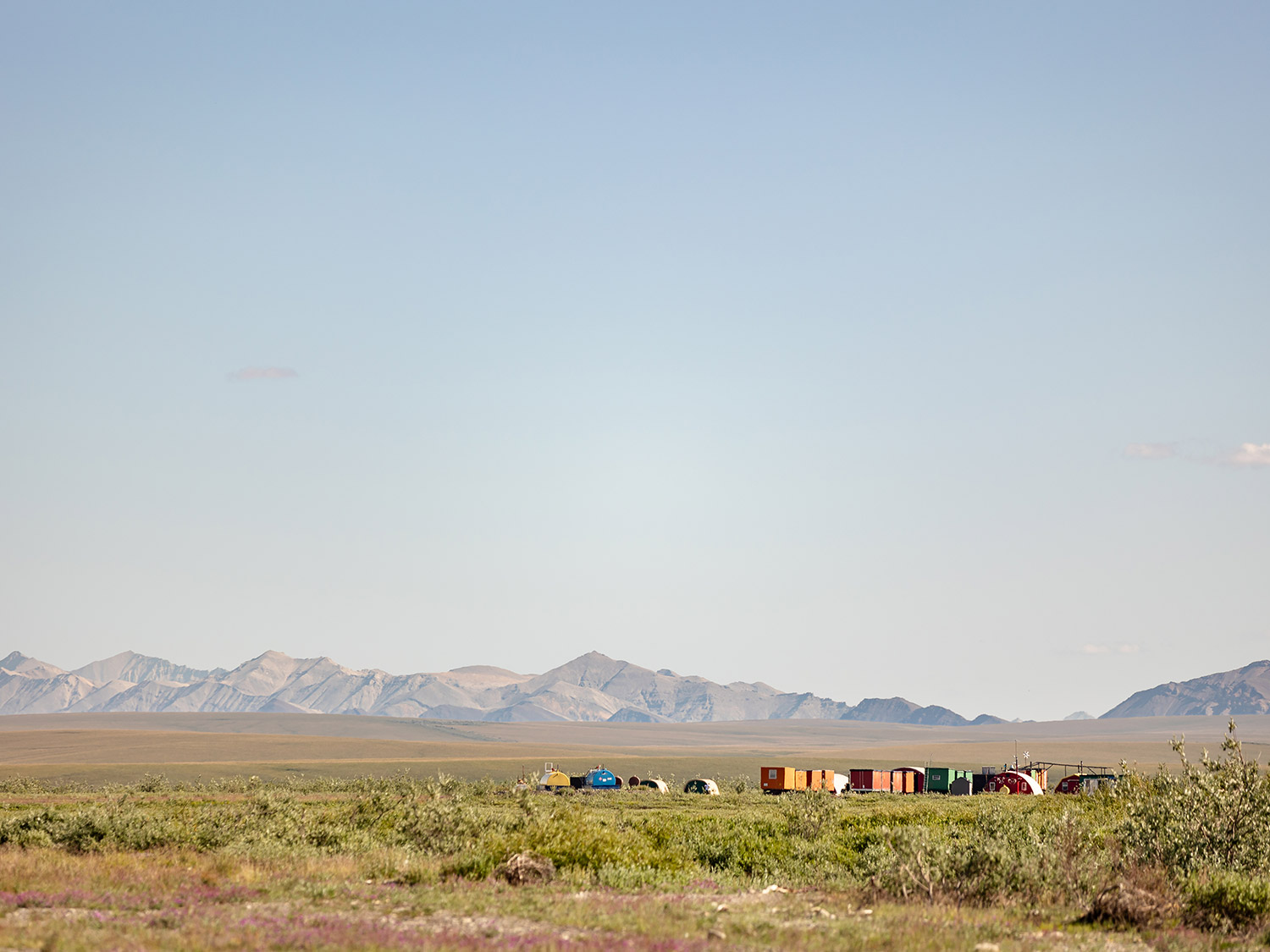 Kavik River Camp Alaska – Remote Arctic Outpost on the North Slope Colorful trailers and structures at Kavik River Camp on Alaska's North Slope, with the Brooks Range mountains in the background across the Arctic tundra