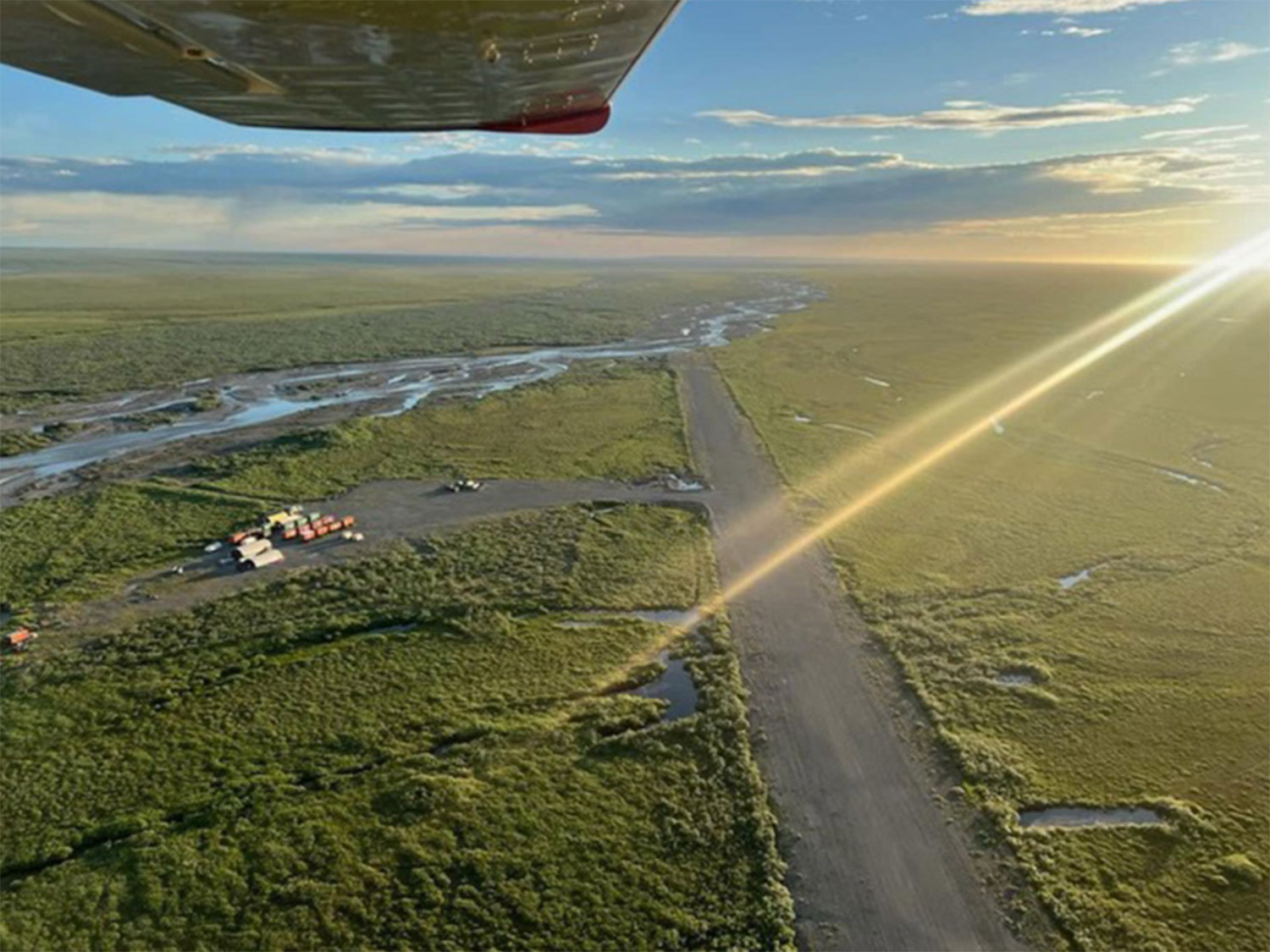 Approaching Kavik River Camp by Bush Plane – Alaska's North Slope Airstrip Aerial view from a bush plane window of Kavik River Camp's gravel airstrip and the Kavik River winding across the Arctic tundra on Alaska's North Slope at golden hour
